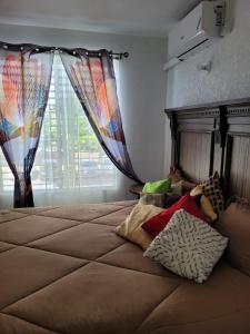 a bedroom with a bed with a window with curtains at New Kingston Gem in Kingston