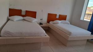 a bedroom with two beds and a window at Hotel Ibiza in Armenia +17 photos