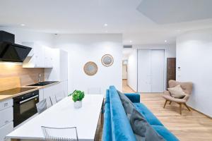 a kitchen and a living room with a blue couch at Trois pièces cozy n14 in Nice +9 photos