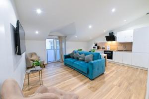 a living room with a blue couch and a kitchen at Trois pièces cozy n14 in Nice