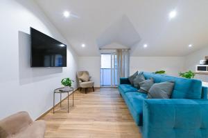 a living room with a blue couch and a flat screen tv at Trois pièces cozy n14 in Nice