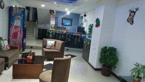 a living room with two chairs and a tv at Hotel Ibiza in Armenia