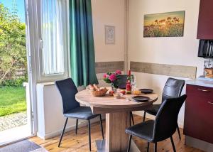 ヴィーク・アウフ・リューゲンにあるstayMA Strandhaus Wiek - Erholen Kitesurfen Wandern und Meerのキッチン(木製のテーブル、椅子、テーブル付) +17枚の写真