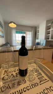 eine Flasche Wein mit zwei Gläsern auf einem Tisch in der Unterkunft Apartamento en el centro urbano in Vilanova i la Geltrú