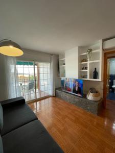 ein Wohnzimmer mit Couch und Flachbildfernseher in der Unterkunft Apartamento en el centro urbano in Vilanova i la Geltrú