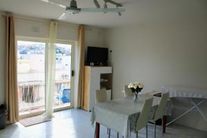 a dining room with a table with a vase of flowers on it at Twin Room with Private Bathroom - Room 1 in Tal-Għoqod