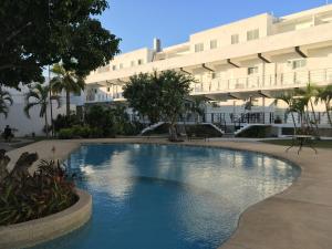 a swimming pool in front of a large building at Departamento con vista al mar in Acapulco