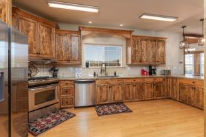 a kitchen with wooden cabinets and stainless steel appliances at Luxury Lodge-Hot Tub-BBQ-Sleeps 18 in Oakhurst