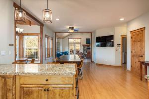 a kitchen and living room with wooden floors and a table at Luxury Lodge-Hot Tub-BBQ-Sleeps 18 in Oakhurst