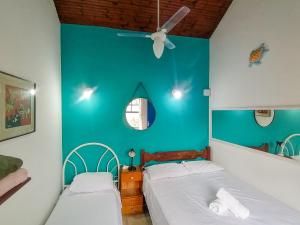2 letti in una camera con parete blu di Casa 12 Búzios Vilas a 500m da Rua das Pedras, top localização em condomínio lindo e calmo, portaria 24h a Búzios Altre 168 foto
