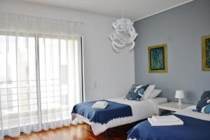 a bedroom with two beds and a large window at Charming Cascais Apt. in Cascais +31 photos