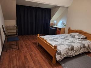 ein Schlafzimmer mit einem Bett und einem Stuhl darin in der Unterkunft SIMLA INDIAAS RESTAURANT VOOR KAMER in Sittard