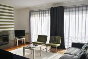 a living room with a couch and chairs and a television at Charming Cascais Apt. in Cascais