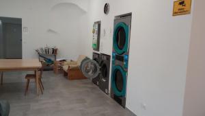 a room with two washing machines next to a table at NRV twee-persoonskamer met gemeenschappelijke keuken in Möderbrugg