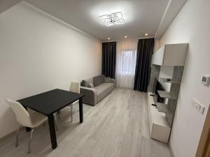 a living room with a table and a couch at Cataleya Suites Apartament's in Bucharest
