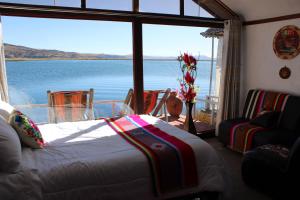 a bedroom with a bed and a view of the water at TITICACA ISLAND LODGe in Puno +6 photos