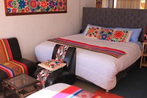 a bedroom with a bed and a chair at TITICACA ISLAND LODGe in Puno