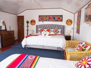 a bedroom with a large white bed with colorful pillows at TITICACA ISLAND LODGe in Puno