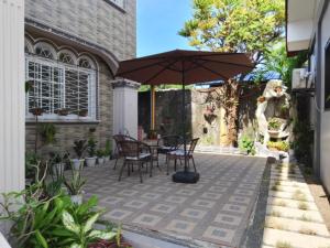 a patio with a table and chairs and an umbrella at Topaz Bed & Breakfast Hotel in San Jose