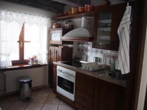a kitchen with wooden cabinets and a white stove top oven at Chalúpka pod Lipkami in Kremnica +63 photos