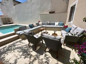 a patio with a couch and chairs next to a pool at Cotton House in Novi Vinodolski