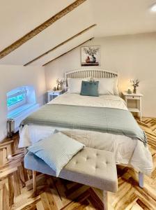 a bedroom with a large bed with a bench in it at Cotton House in Novi Vinodolski
