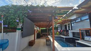 a patio with a swimming pool and a pergola at Jolie Joe's Private Room with Shared Bath in Tagudin