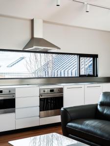 a kitchen with a stove and a couch in a room at The Conservatory in Hobart +10 photos