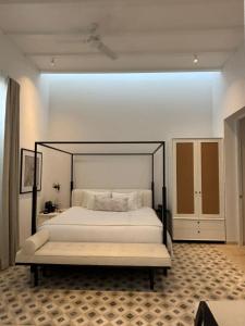 a bedroom with a large bed with a black frame at Casa Continental Hotel Boutique & Suites - Adults Only in Mérida