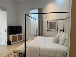 a bedroom with a bed and a flat screen tv at Casa Continental Hotel Boutique & Suites - Adults Only in Mérida