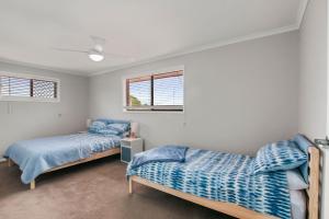 a bedroom with two beds and a window at Bren Place, 6, Battery Hill in Caloundra +5 photos