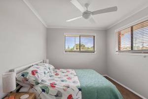a bedroom with a bed and two windows at Bren Place, 6, Battery Hill in Caloundra +5 photos