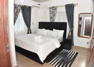 a bedroom with a bed with two towels on it at AC-Apartments in Asaba