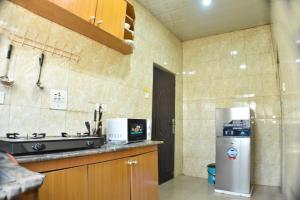 a kitchen with a stainless steel refrigerator and a sink at AC-Apartments in Asaba