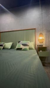 a bedroom with a large bed with a lamp at Estudio Centrico Tulum in Tulum