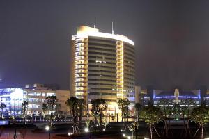 a tall building with lights on it at night at Yiwu Ocean Hotel - Original Best Western Premier Ocean Hotel in Yiwu