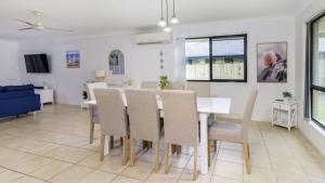a dining room and living room with a table and chairs at Fernando's Beach Hideaway in Banksia Beach