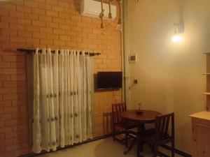 comedor con mesa y cortina en Liyans Eco Villa, en Habaraduwa Central