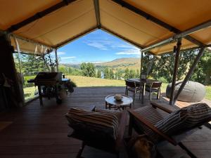 a screened in porch with a view of a grand piano at Tuki Glamping in Havelock North +10 photos