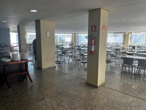 an empty dining room with tables and chairs in a building at Águas da Serra - Apto 2qts in Rio Quente