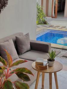 ein Wohnzimmer mit einem Sofa, einem Tisch und einem Pool in der Unterkunft Best Location! 2BR Canggu Villa, 5 Mins to Beach & Hotspots in Canggu