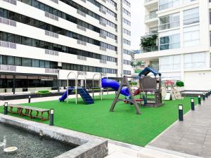 a playground with slides and a swing set in front of a building at Suite en Puerto Santa Ana ,Torres Bellini in Guayaquil