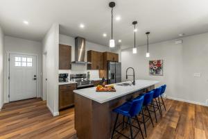 eine Küche mit einer großen Insel mit blauen Barhockern in der Unterkunft The Downtown Duplex - Pet Friendly - NEW BUILD in Colorado Springs