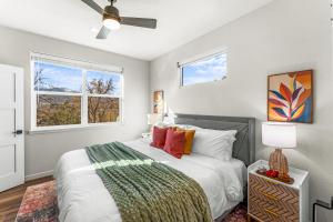 ein Schlafzimmer mit einem Bett und zwei Fenstern in der Unterkunft The Downtown Duplex - Pet Friendly - NEW BUILD in Colorado Springs