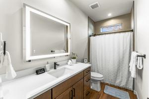 ein weißes Badezimmer mit Waschbecken und Spiegel in der Unterkunft The Downtown Duplex - Pet Friendly - NEW BUILD in Colorado Springs + 28 Fotos