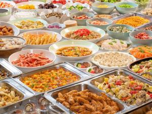 un buffet pieno di diversi tipi di cibo in vassoi di Hotel Daiheigen a Otofuke