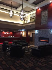 a lobby with couches and a stone fireplace at Chateau Nova Peace River in Peace River