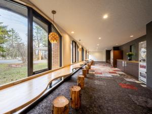 una fila di panche di legno in un edificio con finestre di Hotel Daiheigen a Otofuke