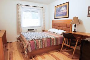 a bedroom with a bed and a desk and a window at Pemberton Hotel (Motel) in Pemberton