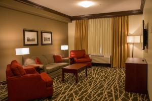 a living room with a couch and chairs in a hotel room at Chateau Nova Peace River in Peace River